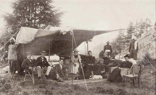 Tea party sotto una tenda con servitori indiani