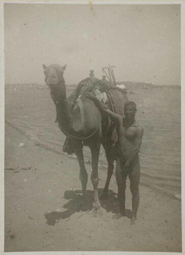 Uomo nudo con dromedario nel deserto