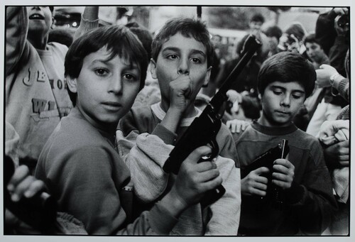 Palermo, 1986. 2 Novembre, il giorno dei Morti. I bambini giocano con le armi che hanno ricevuto in dono.