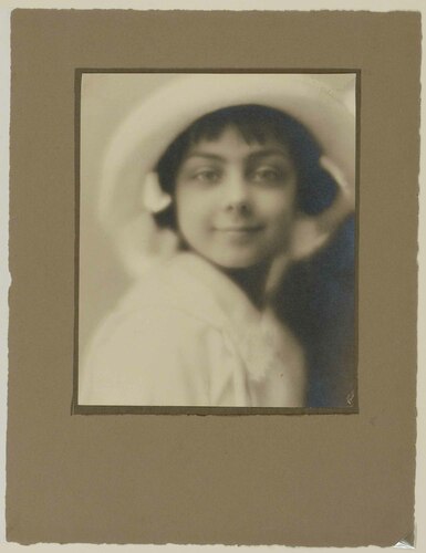 ritratto di bambina sorridente con grande cappello bianco
